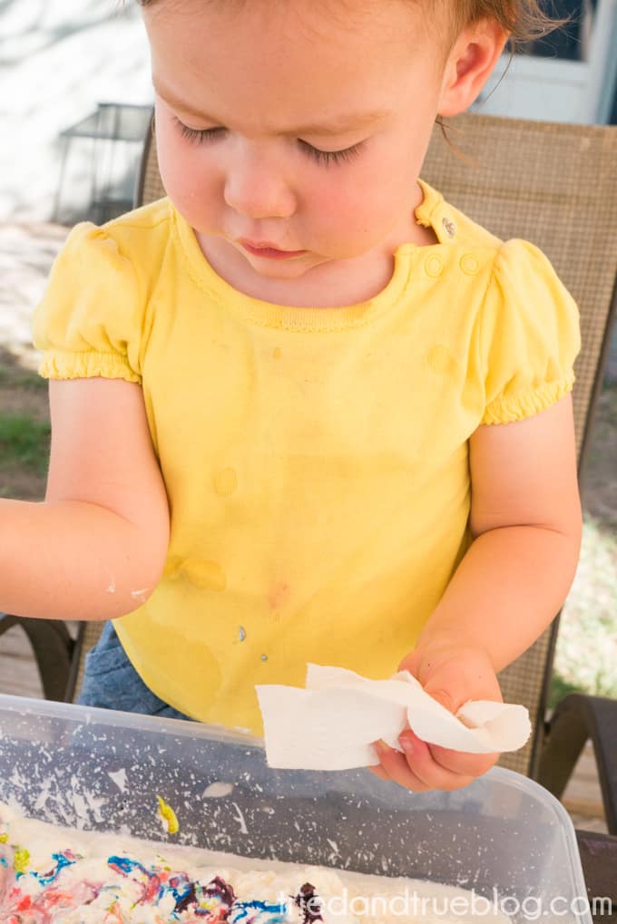 Toddler cleaning up after Unicorn Sensory Play