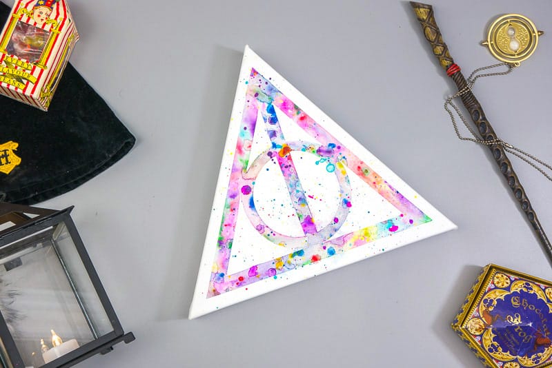 Deathly Hallows watercolor on a gray background.