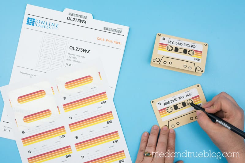 Hand writing out words on a vintage cassette tape card.