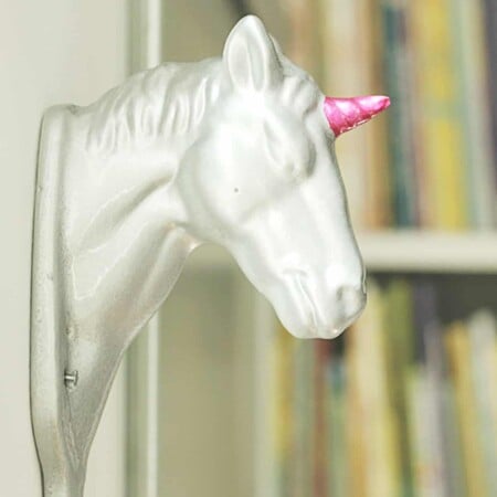 Silver ceramic unicorn with pink horn.