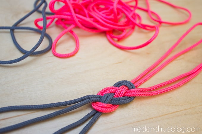 Pink and gray cording tied in knot.