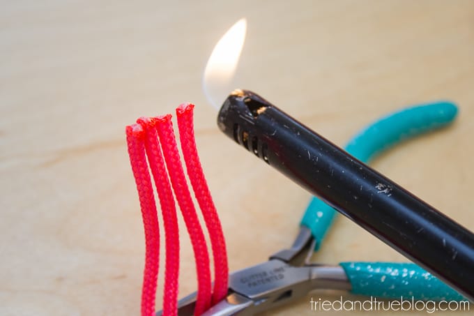 Using a fire lighter to seal the edges of the paracord.