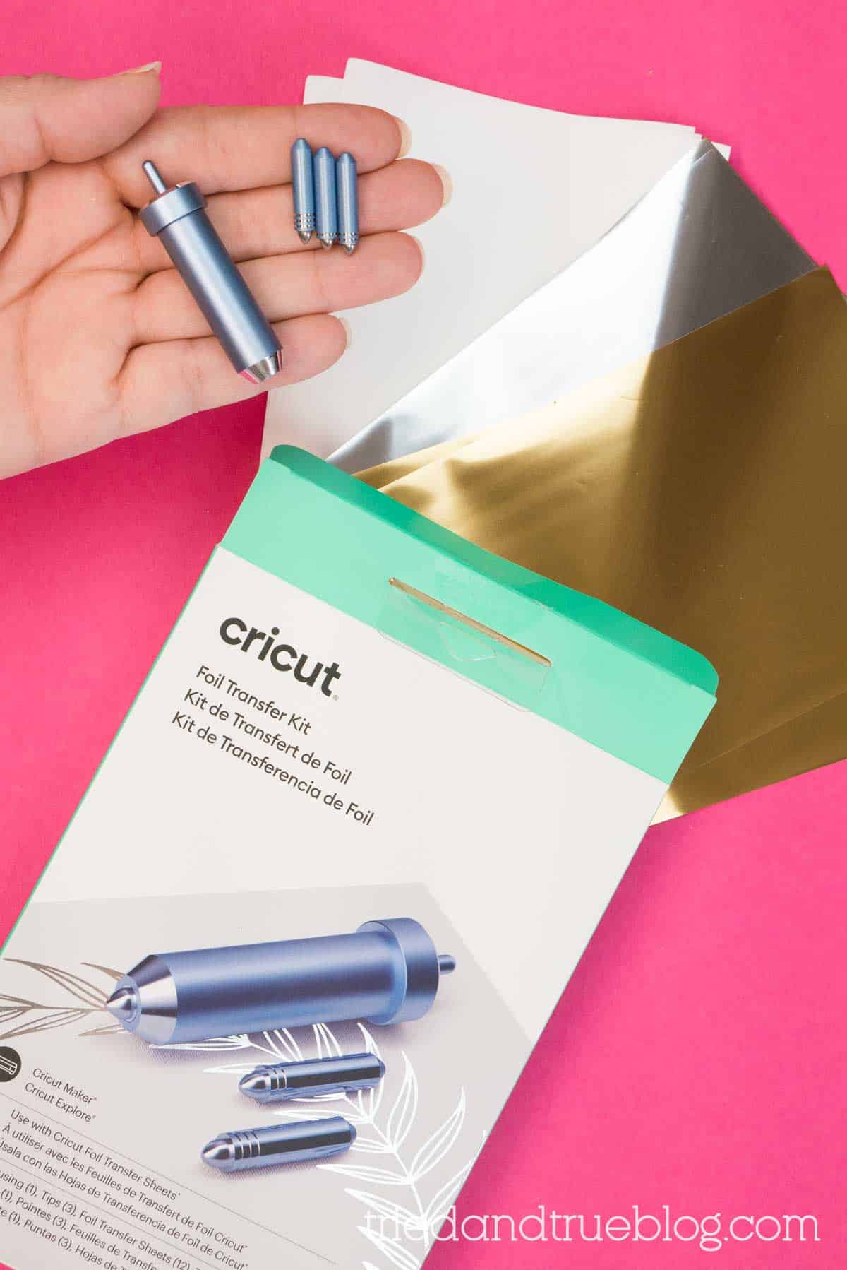 Hand holding Cricut housing unit with foil tips.