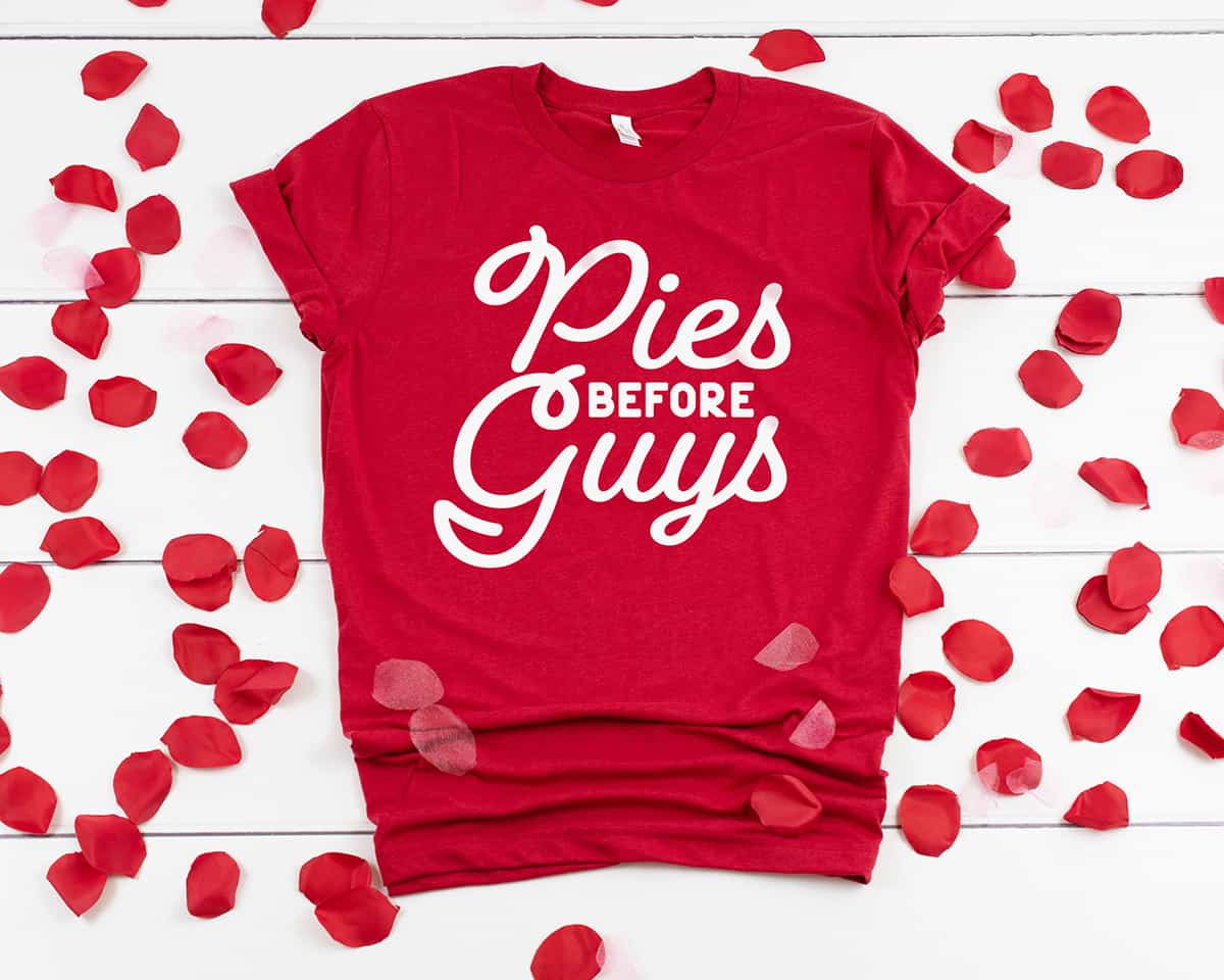 Red t-shirt with the Galentine's Day Free SVG "Pies Before Guys" in white vinyl in the center.