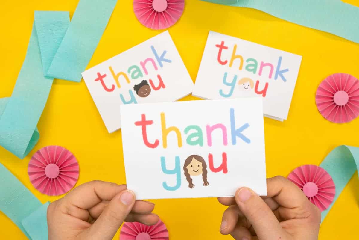 Hand holding card that says "thank you" with a little kid's face.