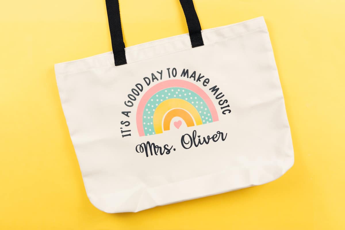 Canvas Infusible Ink bag on yellow background with rainbow and words, "It's a good day to make music. Mrs. Oliver"