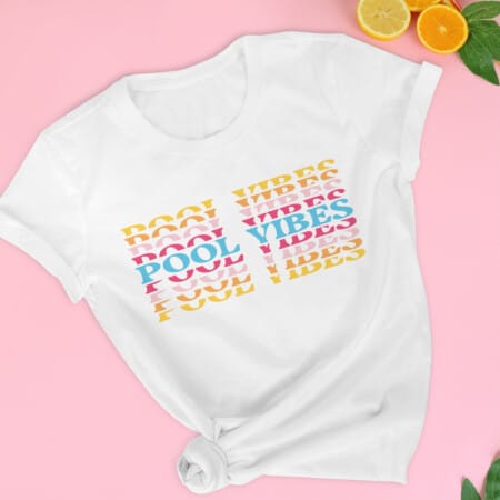 White Tshirt with "Summer Vibes" in multiple colors on pink background