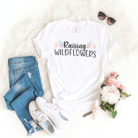 a t - shirt that says raising wildflowers next to a pair of jeans.
