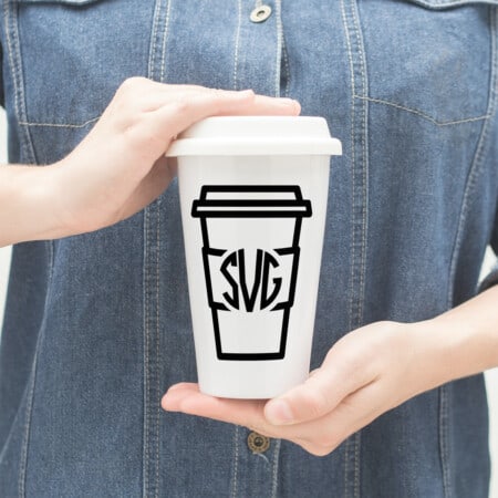 a person holding a cup of coffee with Coffee Lovers Monogram in their hands.
