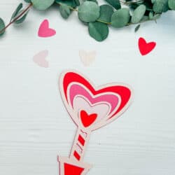 A valentine's day arrow with hearts and eucalyptus leaves.