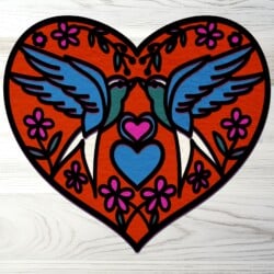 Two birds in a heart shape on a wooden surface.